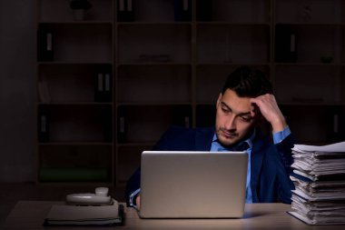 Young employee working late at workplace