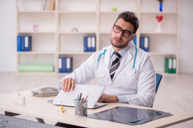 Klinikte çalışan genç erkek doktor.