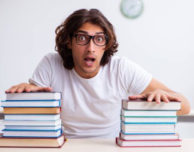 The young male student sitting in the classroom clipart