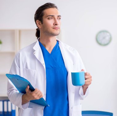Klinikte çalışan genç erkek doktor.