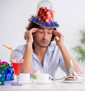 Genç adam doğum gününü evde kutluyor.