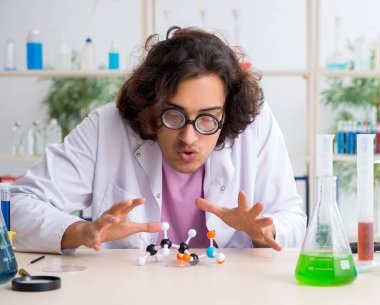 Laboratuvarda çalışan komik erkek kimyager.