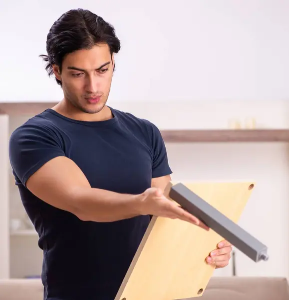 The young man repairing furniture at home