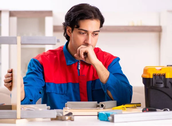 The young contractor repairing furniture at home