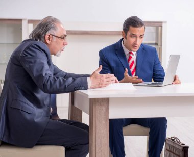 İki işadamı ofiste iş konuşuyorlar.