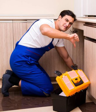 Mutfakta çalışan genç tamirci.