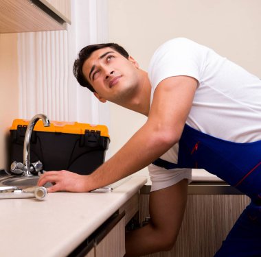 Mutfakta çalışan genç tamirci.