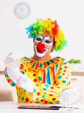 Erkek palyaço evde performansa hazırlanıyor.