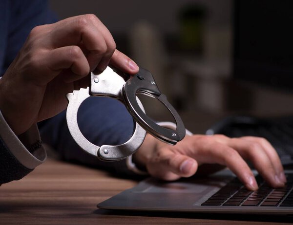 Male hacker hacking security firewall late in the office