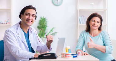 Erkek doktor stomatoloğu ziyaret eden orta yaşlı kadın.