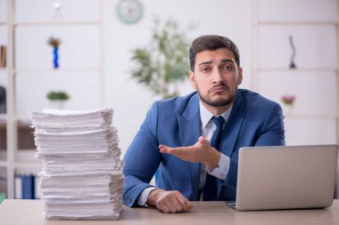Genç bir çalışan ve ofiste çok fazla iş var.