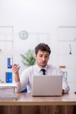 Young employee and too much work at workplace