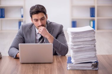 Genç bir çalışan ve ofiste çok fazla iş var.