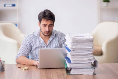 Young employee and too much work at workplace