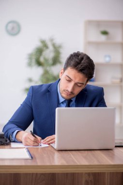 Genç bir çalışan ve ofiste çok fazla iş var.