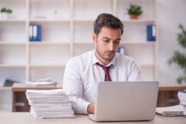 Genç işadamı işyerinde oturuyor.