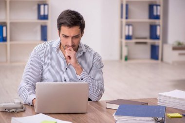 Genç işadamı işyerinde oturuyor.