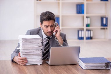 Genç bir çalışan ve ofiste çok fazla iş var.