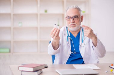 Old doctor sitting at the hospital