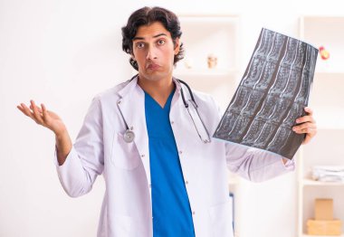 Klinikte çalışan genç erkek radyoloji uzmanı.