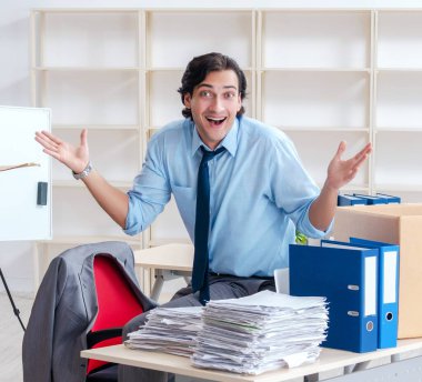 The young man employee with boxes in the office