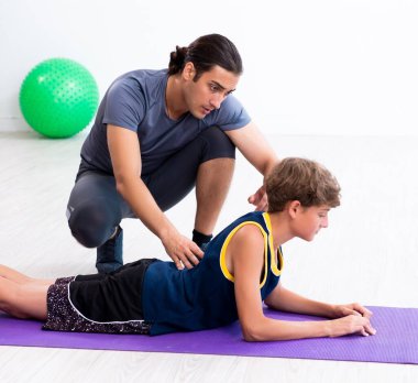 Genç baba ve oğlu egzersiz yapıyor.