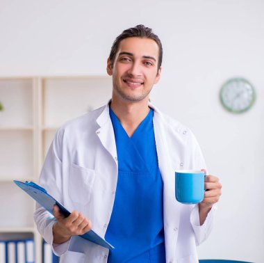 Klinikte çalışan genç erkek doktor.
