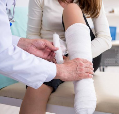 Genç yaralı kadın doktor travmatoloğu ziyaret ediyor.