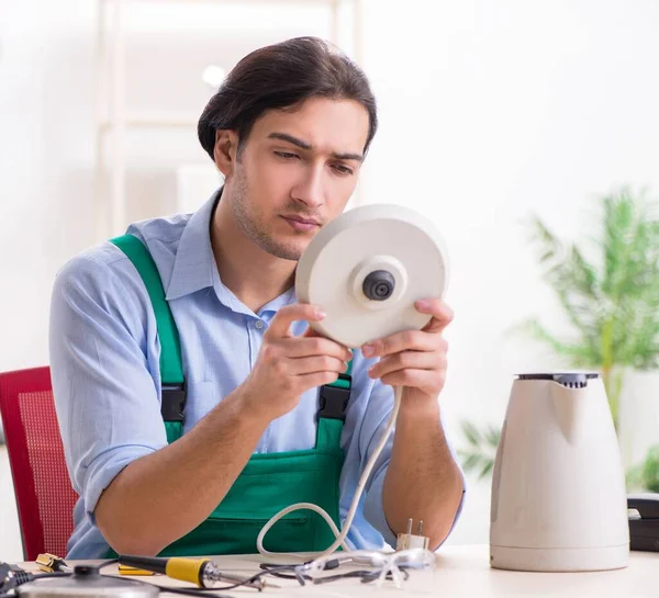The young man repairing kettle in service centre