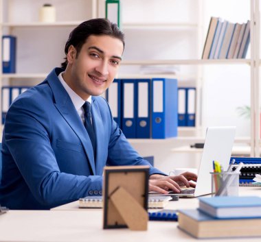 Ofisteki genç ve yakışıklı çalışan.