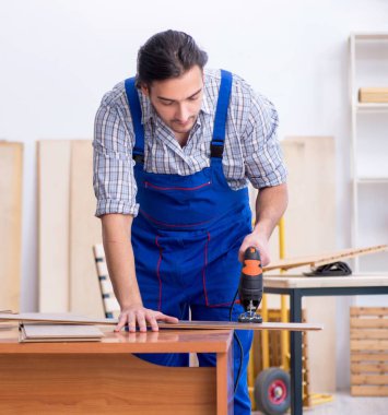 İçeride çalışan genç erkek marangoz.