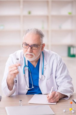 Old doctor sitting at the hospital