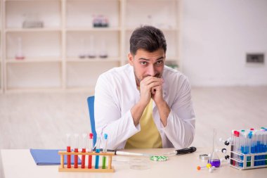 Young chemist sitting at the lab