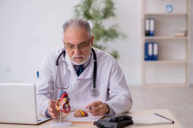 Klinikte çalışan yaşlı bir kardiyolog.