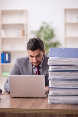 Genç bir çalışan ve ofiste çok fazla iş var.