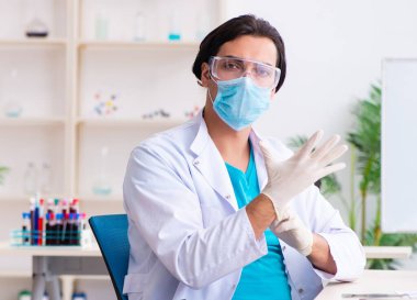 Laboratuvarda çalışan genç erkek kimyager.