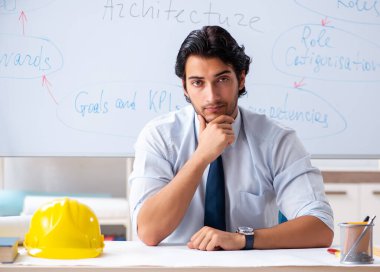 Beyaz tahtanın önündeki genç erkek mimar.