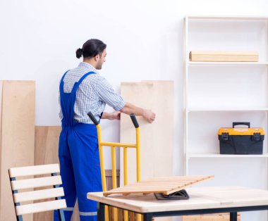 İçeride çalışan genç erkek marangoz.