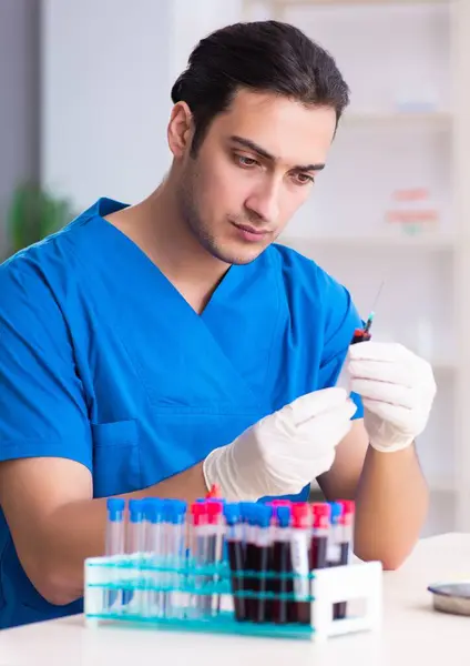 年轻的实验室助理在医院检测血液样本 — 图库照片