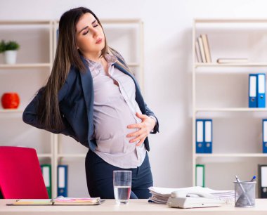 Ofiste çalışan genç hamile kadın.