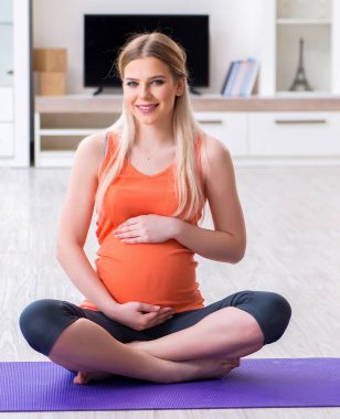 Hamile kadın evde spor yapıyor.