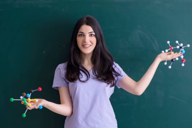 Yeşil panonun önündeki genç bayan öğretmen.