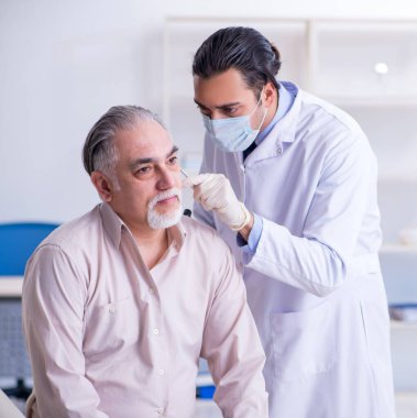 Erkek hasta doktor otolaringolojisti ziyaret ediyor.