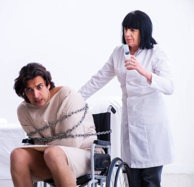 Yaşlı kadın psikiyatrist genç erkek hastayı ziyaret ediyor.