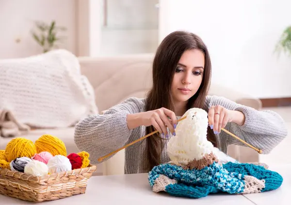 The young beautiful woman knitting at home