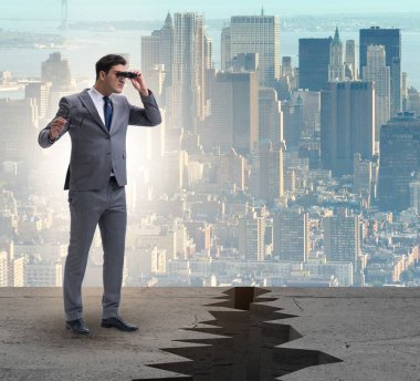 Uçurumun kenarına dürbünle bakan işadamı