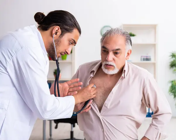 Viejo Visitando Joven Médico Cardiólogo —  Fotos de Stock