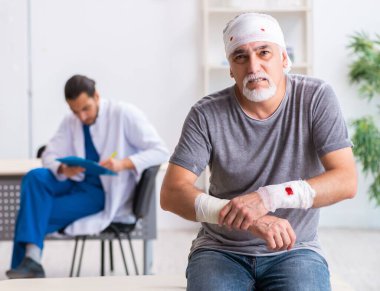 Genç erkek doktor ve yaşlı hasta ilk yardımda.