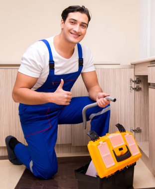 Mutfakta çalışan genç tamirci.