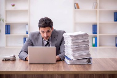 Genç bir çalışan ve ofiste çok fazla iş var.